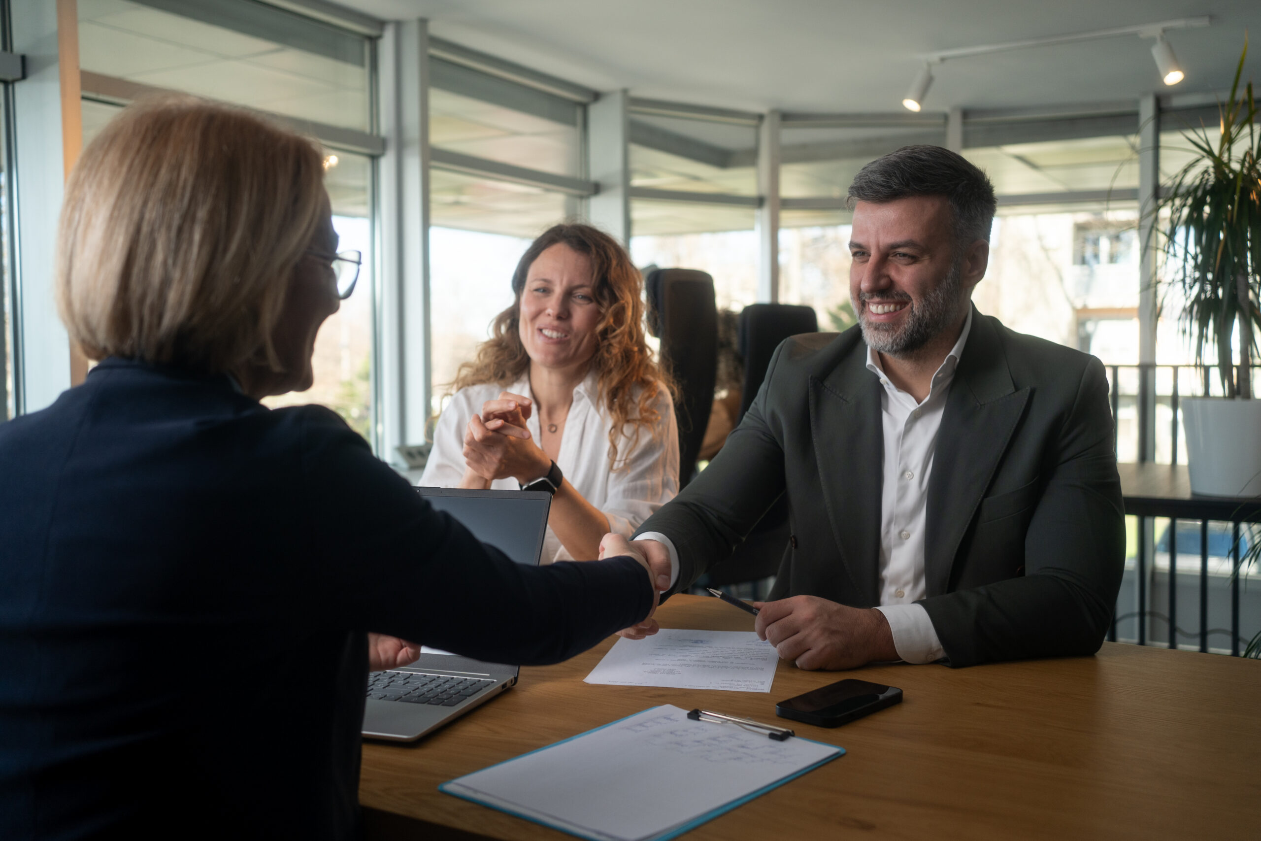 Insurance broker greeting a business client in a meeting room
